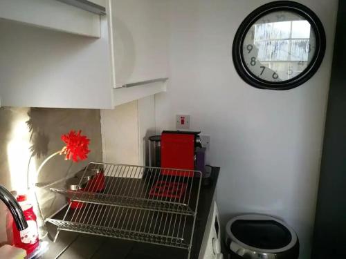 a kitchen with a clock on the wall and a shelf at University and Central Edinburgh in Edinburgh
