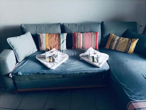 Un sofá azul con dos platos de comida. en Le tout à pied!, en Ciboure