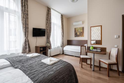 a hotel room with a bed and a table and chairs at Elit Boutique Rooms- Best Location by BQA in Budapest