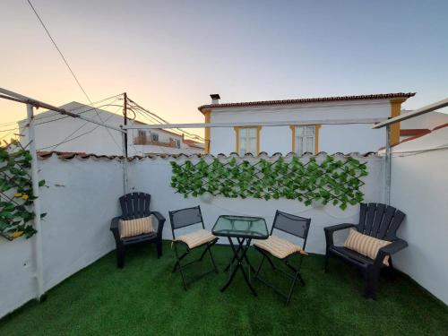 eine Terrasse mit 4 Stühlen und einem Glastisch in der Unterkunft Catespero Sossego in Reguengos de Monsaraz
