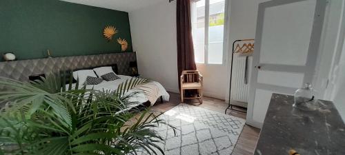 1 dormitorio con 1 cama con pared verde en Gîte Sous le Tilleul - Tourouvre - Perche, en La Ventrouze