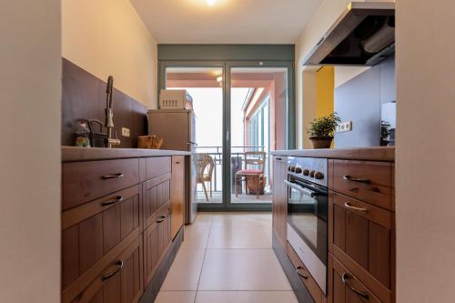 a kitchen with wooden cabinets and a refrigerator at BohnApartments Bauhaus - absolutes Zentrum - Terrasse - Vollausstattung - WLAN in Weimar