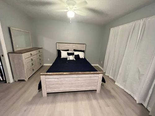 a bedroom with a bed and a dresser and a mirror at Cypress Cove Waterfront Townhome with Boat Ramp in Inverness