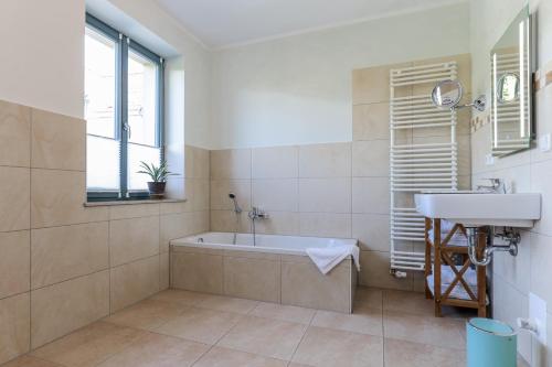 a bathroom with a bath tub and a sink at BohnApartments Bauhaus - absolutes Zentrum - Terrasse - Vollausstattung - WLAN in Weimar