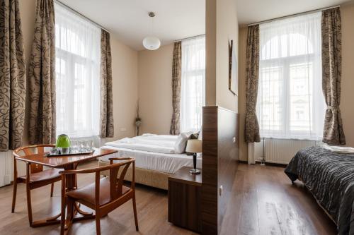 a hotel room with a bed and a table and chairs at Elit Boutique Rooms- Best Location by BQA in Budapest