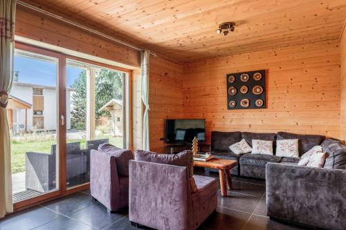 a living room with a couch and a tv and a table at Chalet Sherpa - Welkeys in LʼHuez