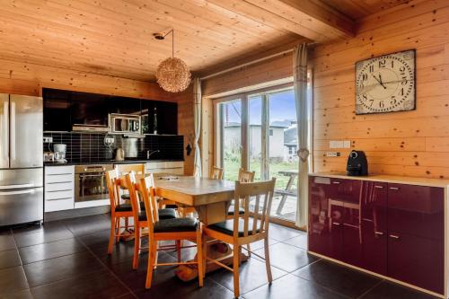LʼHuezにあるChalet Sherpa - Welkeysのキッチン(テーブル、椅子、壁掛け時計付)