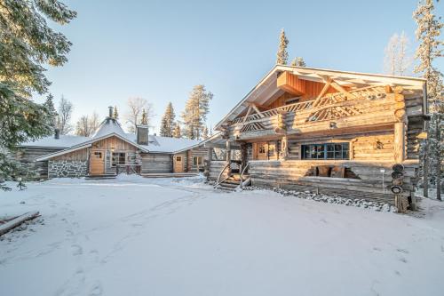 uma cabana de madeira na neve com uma entrada em Lapland Lodge em Tepsa