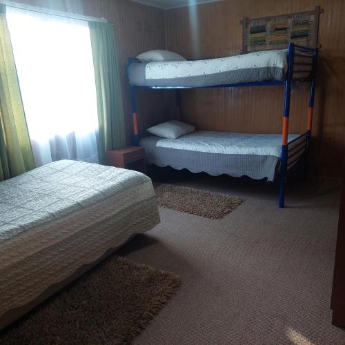a bedroom with two bunk beds and a window at Agroturismo los Colihues in Castro