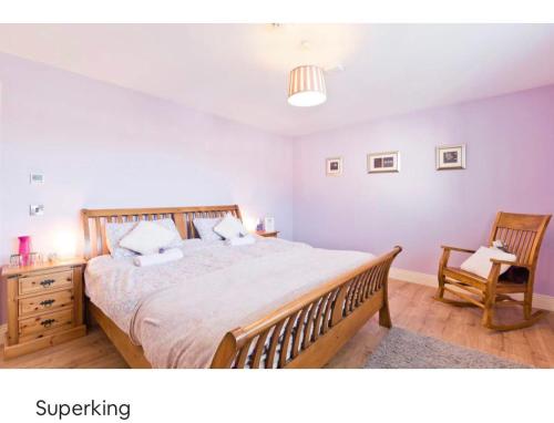 1 dormitorio con 1 cama grande y 1 silla en Modern Homestay Rooms Dublin Airport 15 minutes, en Ballyboughal