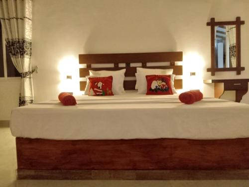 a bedroom with a large white bed with red pillows at Indika's Apartment in Hikkaduwa