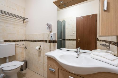 a bathroom with a sink and a toilet at Elit Boutique Rooms- Best Location by BQA in Budapest