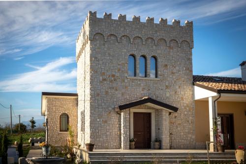 un gran edificio de ladrillo con una torre con ventanas en La Torre B&B Home and Relax en Amorosi