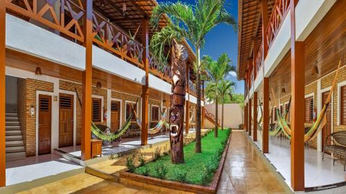 a room with a palm tree in the middle of a building at Hotel Jeri in Jericoacoara