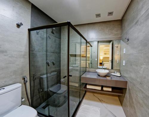 a bathroom with a shower and a toilet and a sink at Gaeta Hotel in Guarapari