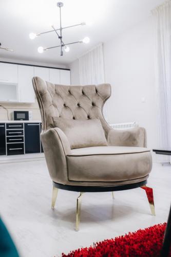 a chair sitting in a living room in a room at Garni Hotel Radović in Kragujevac