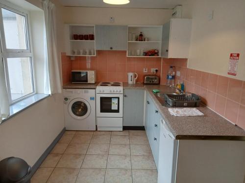 uma cozinha com um lavatório e uma máquina de lavar roupa em 39 Marine Court Apartment em Bundoran