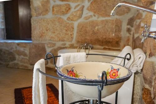 a bath tub with a sink in a bathroom at O Refúgio da Serra do Caramulo in Caramulo