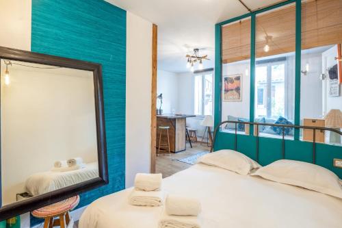 um espelho num quarto com uma cama e uma mesa em Elegant flat near the centre of Bordeaux - Welkeys em Bordeaux