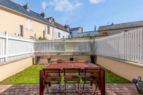 een groep banken op een patio met een wit hek bij Design house in the center of Deauville - Welkeys in Deauville