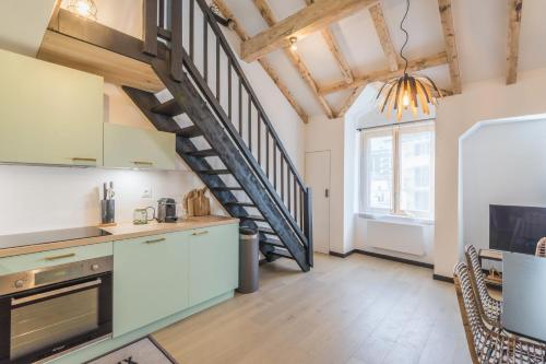 une cuisine avec un escalier en colimaçon dans un loft dans l'établissement Appartement Jorasses - Welkeys, à Chamonix-Mont-Blanc