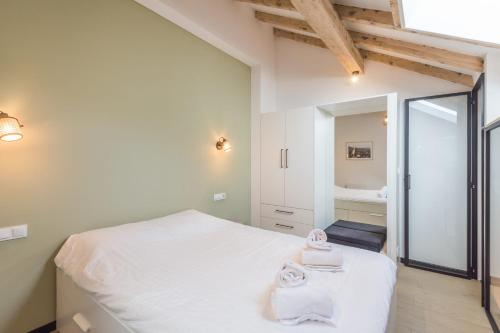- une chambre avec un lit blanc et un miroir dans l'établissement Appartement Jorasses - Welkeys, à Chamonix-Mont-Blanc