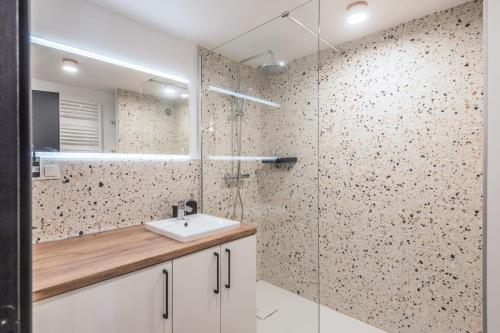 une salle de bain avec un lavabo et une douche en verre dans l'établissement Appartement Jorasses - Welkeys, à Chamonix-Mont-Blanc