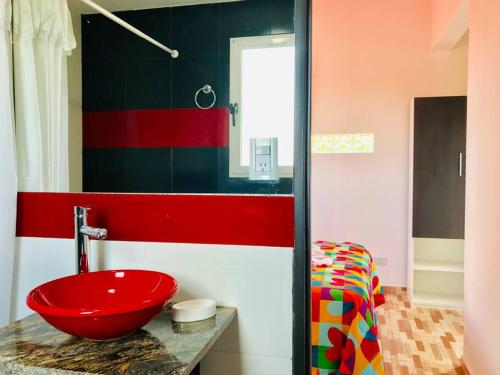 a bathroom with a red bowl sink on a counter at LA MILAGROS ZORZAL COLORADO in Merlo