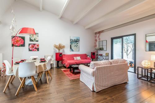 ein Wohnzimmer mit einem roten Sofa und einem Tisch in der Unterkunft Maison Avocette - Welkeys in La Rochelle