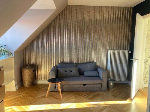 una sala de estar con un sofá azul en un ático en Cosy room in residential part of Copenhagen, with free street parking and shared bathroom en Copenhague