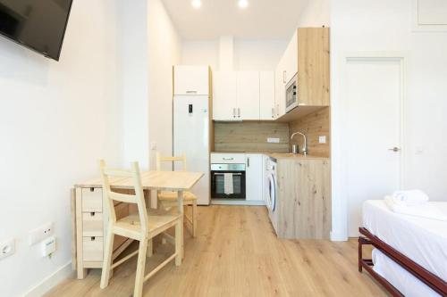 una pequeña cocina con mesa y sillas en una habitación en Coqueto apartamento en la calle Caribe. A/C WIFI, en Madrid