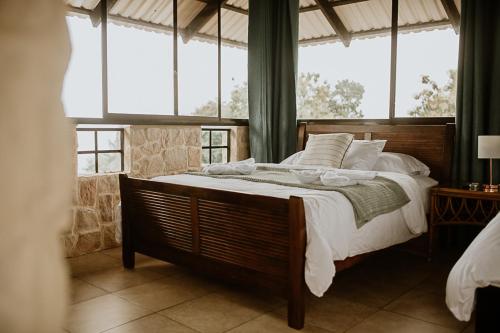 a bedroom with a large bed in a room with windows at Castillo Tambor Resort & Restaurant in Tambor