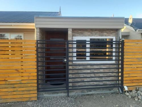 a fence with a gate in front of a house at Departamento con acceso independiente - English spoken in Punta Arenas