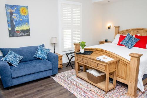 ein Schlafzimmer mit einem Bett und einem blauen Sofa in der Unterkunft Pomar House in St. Augustine