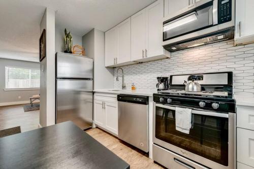 a kitchen with a stainless steel stove and refrigerator at Global Cup The Eastside Flat Arboretum Tickets Included in Dallas