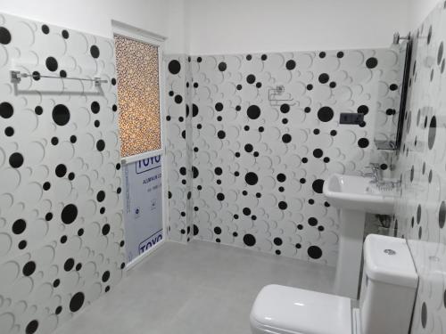 a bathroom with black and white polka dots on the wall at Indika's Apartment in Hikkaduwa