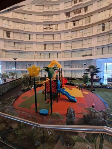 a playground in front of a large building at Honest Homes at Rajhans Belliza, Appartment Units in Surat