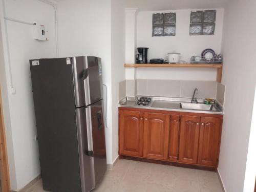 a kitchen with a refrigerator and a sink at Estadio APARTE HOTEL 203 in Medellín