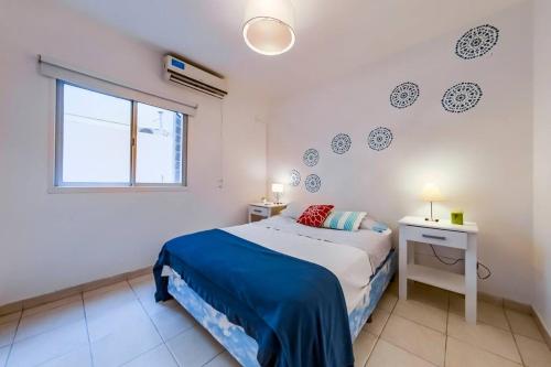 Habitación blanca con cama y ventana en Bolívar 775 - B Güemes en Córdoba