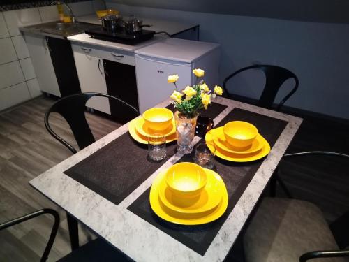 a table with yellow hats and yellow plates on it at House For Rest in Belgrade