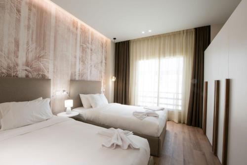 a hotel room with two beds and a window at New Cairo, Akoya Residence, Milena in New cairo