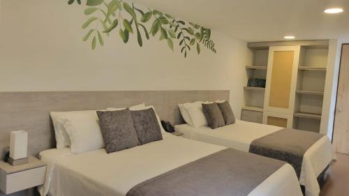 馬尼薩萊斯的住宿－Hotel Piedras De Maní，一间带两张床的卧室和植物