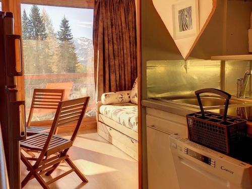 une cuisine avec une table et deux chaises ainsi qu'une fenêtre dans l'établissement Studio lumineux proche centre avec balcon - FR-1-346-445, à Arc 1800