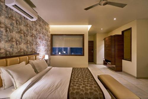 Schlafzimmer mit einem großen Bett und einem Deckenventilator in der Unterkunft Hotel Shlok- Pure Veg , Kolhapur in Kolhapur