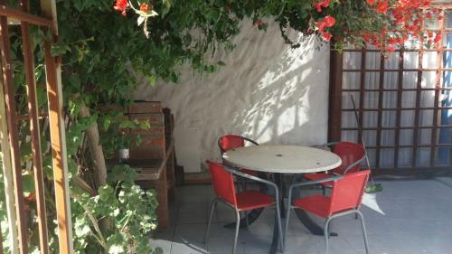 una mesa y sillas en un patio con flores en Casa Norma santiago 8 personas en Santiago
