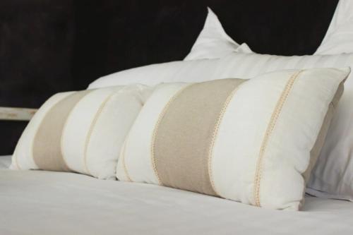 a row of pillows sitting on top of a bed at Vanadis, Suites d'exceptions & spa - LE BALNEO in Pacy-sur-Eure