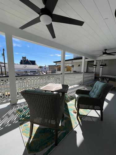 a porch with two chairs and a ceiling fan at Elaine's Cape May Boutique Hotel in Cape May
