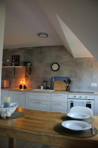 a kitchen with a wooden table with white plates on it at NordApart - Butjadingen in Butjadingen