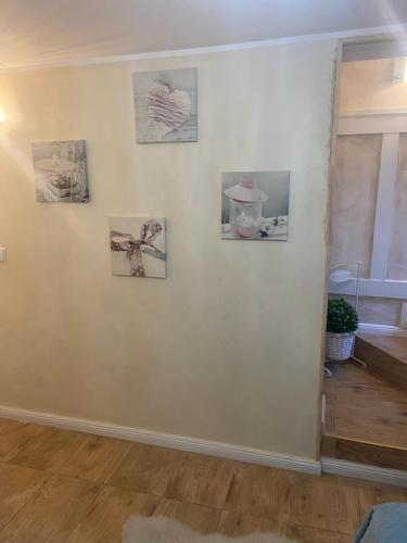 ein Zimmer mit vier Bildern an einer weißen Wand in der Unterkunft Mały apartament z kuchnią i łazienką in Stettin