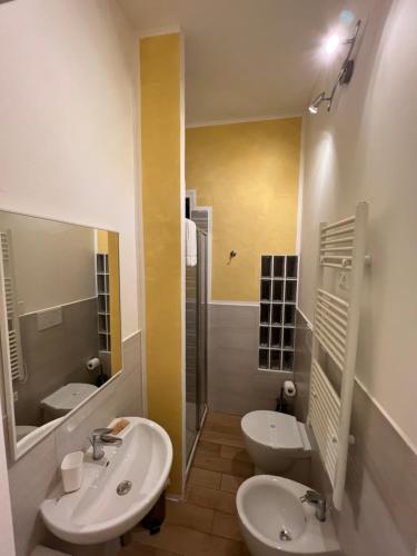 a white bathroom with two sinks and a shower at butterfly b&b in Livorno